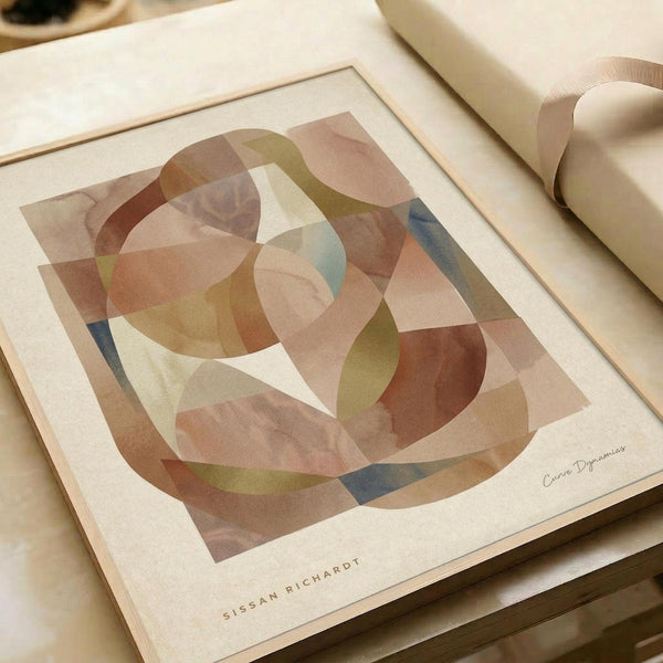 May include: Abstract geometric art print in warm earth tones featuring overlapping translucent shapes in browns, greens, and muted blues. The artwork shows curved and angular forms creating layered patterns with a watercolor-like texture. Displayed in a light wooden frame on neutral paper with an artist signature, sitting on a cream surface next to rolled paper tubes.