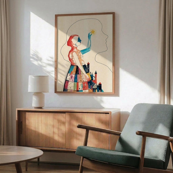 May include: Colorful abstract art print in wooden frame showing stylized figure with red hair reaching toward a star, lower body formed by geometric houses in blues, reds, and yellows. Print displayed above mid-century wooden credenza with ceramic lamp in bright living room with sage green armchair, round coffee table, and natural sunlight streaming across white walls.