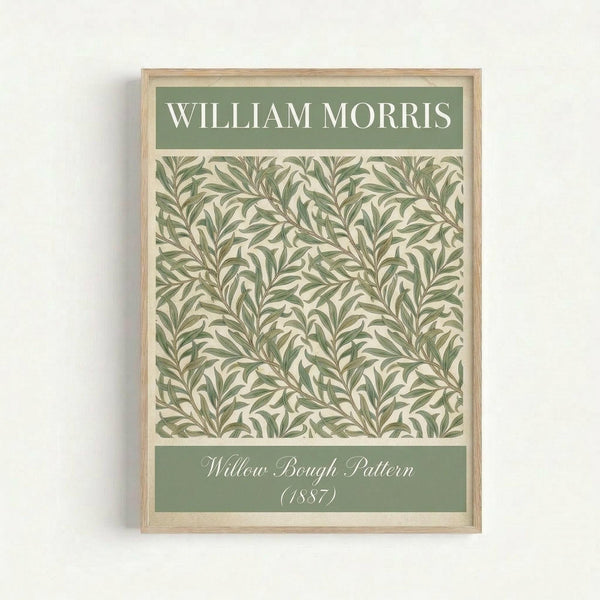 Framed botanical art print featuring William Morris's Willow Bough pattern from 1887. The design shows intricate green willow branches and leaves in a repeating pattern against a cream background. The print has green header and footer bands with white text identifying the artist and pattern name. The artwork is displayed in a light wood frame against a white wall.