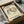 May include: Framed vintage-style exhibition poster featuring dancing figures in green, brown and cream colors, displayed in black frame inside cardboard shipping box with protective wrapping materials on white surface
