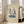 May include: Framed poster with cream background showing two stylized figures dancing on top of a blue vinyl record turntable, displayed on light wooden floors beside a beige sofa near bright windows in a minimalist living room setting
