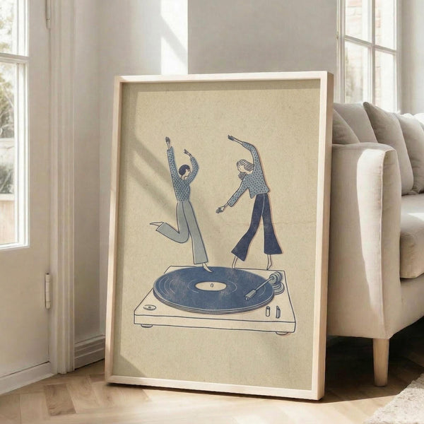 May include: Framed poster with cream background showing two stylized figures dancing on top of a blue vinyl record turntable, displayed on light wooden floors beside a beige sofa near bright windows in a minimalist living room setting