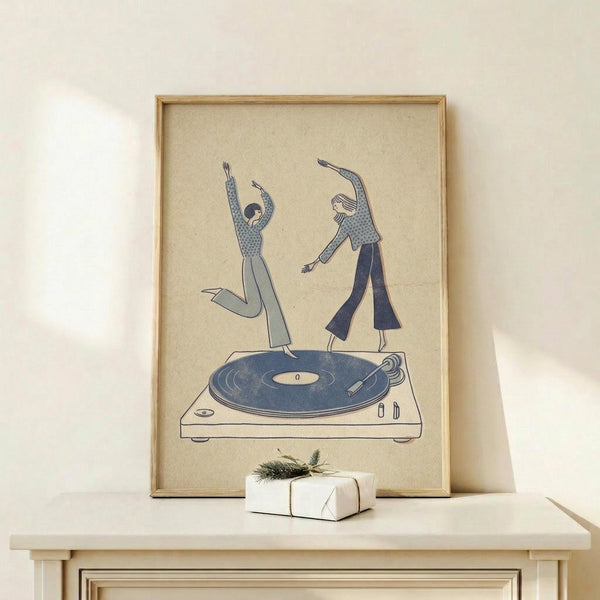 May include: Minimalist line art poster in light wooden frame showing two people dancing on a turntable record player, rendered in muted blue and beige tones on cream background. Frame displayed on white wooden surface next to small wrapped gift with evergreen sprig. Clean, modern aesthetic with simple illustrated figures in casual clothing striking dynamic dance poses.