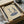 May include: Minimalist line art print showing two dancing figures with flowing movements positioned above a vintage turntable with vinyl record. Artwork features navy blue and cream tones on beige paper, displayed in black frame inside cardboard shipping box with protective tissue paper and wooden dowels for packaging.