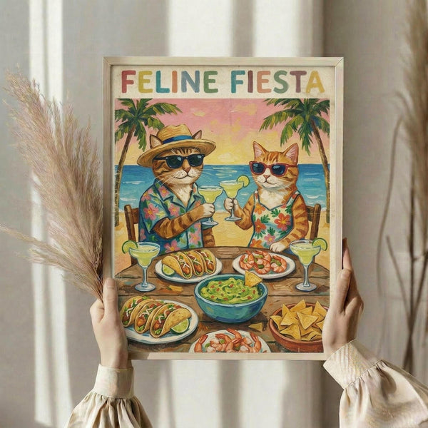 May include: Person holding framed poster showing two cats in Hawaiian shirts and sunglasses sitting at beach table with tacos, margaritas, and Mexican food. Tropical sunset scene with palm trees and ocean in background. Colorful text reads "FELINE FIESTA" at top. Light wood frame, held against neutral curtained window with dried pampas grass visible on left side.
