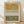 May include: Abstract art print in light wood frame leaning against white wall on wooden floor. Artwork features horizontal bands of ochre yellow and olive green watercolor washes separated by black geometric patterns including chevrons, dashes, and crosses on cream background.