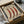 May include: Vintage-style botanical poster featuring three red chili peppers with white spots, displayed in black frame inside brown cardboard shipping box with white tissue paper. Warm cream background with brown serif text. Box sits on white surface with wrapped items nearby.
