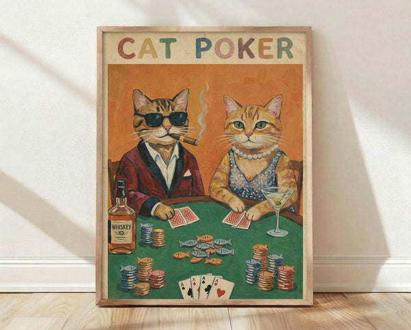 May include: Framed vintage-style poster showing two anthropomorphic cats playing poker at green felt table. Orange tabby cat wears sunglasses, burgundy jacket, smoking cigar. Second cat in pearl necklace holds martini glass. Poker chips, whiskey bottle, playing cards, and small fish scattered on table. Warm orange background. Light wood frame displayed on wooden floor against white wall.