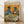 May include: Framed poster print leaning against white wall on light wood floor. Artwork shows two anthropomorphic pigeons wearing sunglasses and vintage clothing sitting at green round table with brunch items including avocado toast, croissant, pancakes, and coffee cups. Orange painted background with "PIGEON BRUNCH" text at top in colorful letters. Natural wood frame, warm lighting with soft shadows.