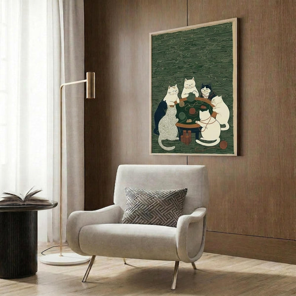 May include: Framed poster print showing cats gathered around a small table with yarn balls in a green textured background, displayed on wood paneled wall above beige upholstered armchair with geometric patterned pillow, brass floor lamp and side table with open book nearby in modern living room setting