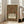 May include: Ornate vintage-style poster with intricate floral border design in earthy tones of rust, green, and gold. Features decorative bird among botanical motifs surrounding central text panel reading "ART & SOCIALISM" with subtitle about William Morris celebration. White wooden frame displayed on wooden floor beside beige upholstered sofa in bright, window-filled living room with white walls.