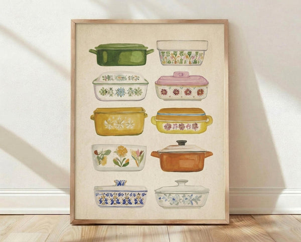 May include: Framed watercolor poster displaying ten vintage-style casserole dishes arranged in rows, featuring colorful floral patterns in green, pink, yellow, orange and blue tones against cream background, shown leaning against white wall on light wood floor with natural lighting and soft shadows