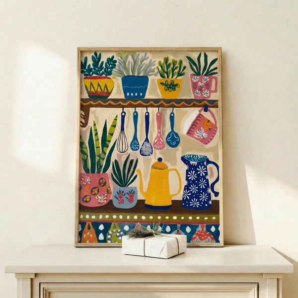 May include: A framed folk art kitchen print displayed on a light wood console table with a small wrapped gift box. The colorful illustration features stylized potted plants on shelves, hanging kitchen utensils, teapots, and mugs in vibrant blues, yellows, pinks and greens with decorative patterns. The artwork has a whimsical, hand-painted appearance with botanical elements and kitchen items arranged in horizontal bands against a cream background.