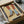 May include: Framed illustration of legs wearing red and white striped tights with gray socks and brown leather shoes, displayed in black frame within cardboard shipping box surrounded by protective tissue paper and wooden dowels