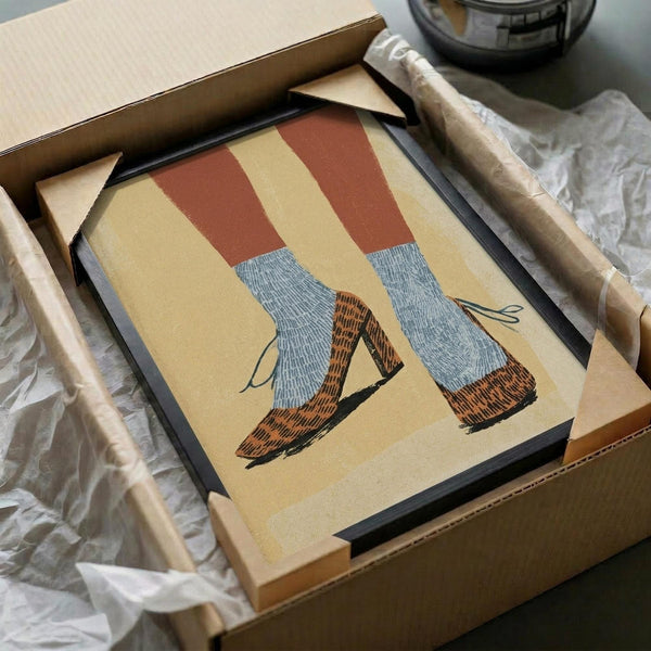 May include: Framed illustration of legs wearing red and white striped tights with gray socks and brown leather shoes, displayed in black frame within cardboard shipping box surrounded by protective tissue paper and wooden dowels
