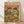 May include: Framed poster print leaning against white wall on light wood floor. Artwork shows two cartoon frogs wearing sunglasses and hats at a fiesta celebration with colorful Mexican food spread including tacos, guacamole, chips, and tequila bottles. Orange background with hanging piñatas. One frog wears a striped poncho and sombrero holding a margarita, the other wears a fedora and bow tie holding a taco. Vibrant colors throughout with wooden frame.