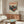 May include: Vintage-style Japanese poster featuring red turntable with Mount Fuji backdrop, displayed above mid-century walnut credenza in modern living room with white curved chair, brass floor lamp, oval glass coffee table, and white table lamp creating warm natural lighting