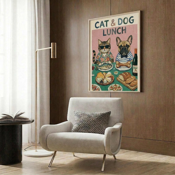 May include: Whimsical illustrated poster showing a tabby cat in floral shirt and French bulldog in striped shirt sitting at green table with plates of food, cheese, bread and wine bottle. Framed artwork hangs on wood-paneled wall above beige upholstered armchair with geometric pillow. Modern brass floor lamp and side table with open book complete the cozy interior scene.