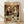 May include: Framed poster print leaning against white wall on light wood floor. Artwork shows two white ducks with orange bills dressed formally - one in dark suit holding red roses, one in elegant dress. They sit at candlelit dinner table with wine, chocolates, and fine dining items in ornate room with crystal chandelier and red curtains. Vintage romantic illustration style with warm golden lighting.