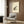May include: Japanese-style frog artwork displayed in modern living room with beige armchair, geometric pillow, brass floor lamp, and dark wood paneling. The vintage-inspired print features a spotted frog on aged paper with Asian calligraphy, framed and hung above a minimalist seating area with warm neutral tones throughout.