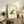 May include: Framed traditional Japanese-style artwork featuring a spotted brown and tan frog with red seal stamps and Asian characters, displayed on a rustic wooden console table alongside decorative pottery, books, and a fern plant in a neutral-toned living room setting.