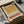 May include: Framed abstract art print with earthy geometric design featuring mustard yellow, terracotta orange, and black dotted pattern sections on cream background, displayed in black frame on wooden surface with tissue paper packaging and cardboard shipping materials
