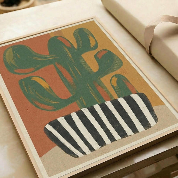 Abstract illustration featuring a stylized green cactus with flowing, curved arms against a warm gradient background of coral, orange and yellow tones. The cactus sits in a black and white striped geometric pot. The artwork has a retro, mid-century modern aesthetic with soft brushstroke textures and earthy colors. Print is displayed on white paper with visible edges, photographed on a light surface next to rolled white paper tubes.