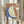 May include: Person holding framed abstract artwork featuring terracotta, sage green, and blue organic shapes with white outlines and a cream circle resembling a moon, displayed against white curtains with dried pampas grass visible to the left