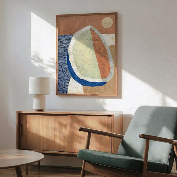 May include: Abstract artwork in wooden frame showing organic curved shapes in terracotta, sage green, and cream with blue accents and circular moon element, displayed above mid-century modern wooden sideboard with ceramic table lamp, next to sage green upholstered armchair with wooden frame in sunlit room with white walls