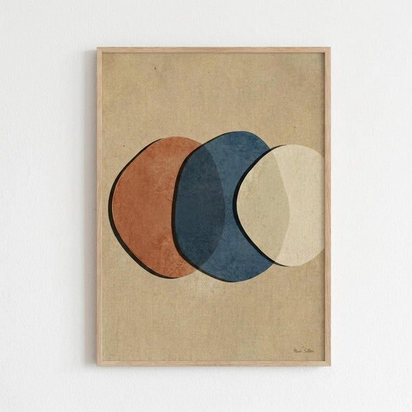 Geometric abstract artwork featuring three overlapping circles in terracotta orange, deep blue, and cream colors on a tan textured background. The minimalist composition is displayed in a light wood frame hanging on a white wall, with the circles creating subtle layered intersections and a balanced modern aesthetic.