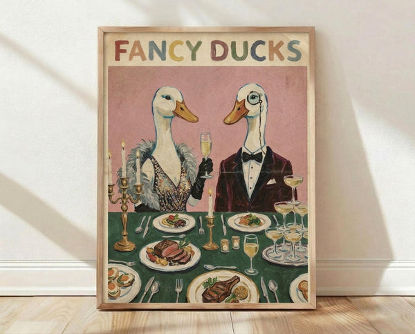 May include: Framed vintage-style poster showing two elegant ducks in formal attire at a dinner table. The female duck wears a beaded evening gown with feather boa, while the male sports a burgundy tuxedo with bow tie and monocle. They're seated at a green tablecloth-covered table laden with fine dining elements including champagne flutes, candelabras, plates of gourmet food, and silverware. The illustration has a whimsical anthropomorphic style with "FANCY DUCKS" text at the top in colorful l