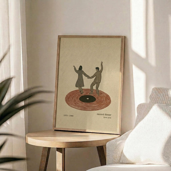 May include: Framed poster showing two silhouetted figures dancing on a red vinyl record, displayed on a round wooden side table next to a beige upholstered chair. Natural sunlight streams across the neutral-toned room, casting soft shadows. The artwork features a cream background with text reading "1970-1980" and "record danar love you" beneath the dancing couple illustration.