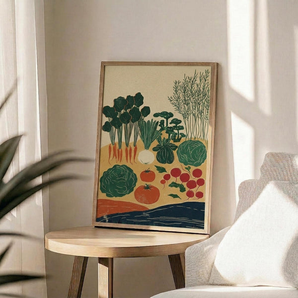 May include: Framed botanical illustration displaying various vegetables including green cabbages, orange carrots with leafy tops, red tomatoes and radishes, herbs, and other garden produce arranged on cream background with blue accent stripe at bottom. Natural wood frame sits on round wooden side table next to beige upholstered chair with plant shadows cast by window light on white wall.