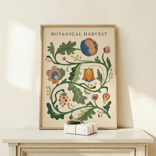May include: Framed botanical poster with decorative floral vine design featuring colorful flowers in blue, orange, and pink tones with green leaves and small berries, displayed on light wood shelf next to small white wrapped gift with evergreen sprig, against cream colored wall