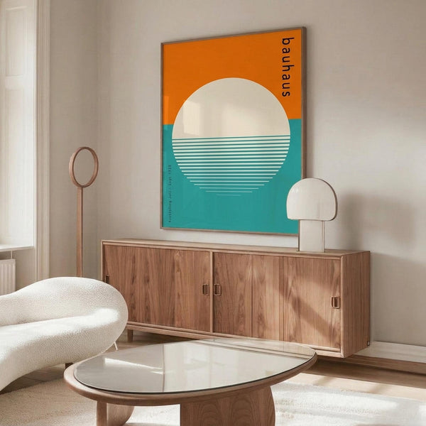 May include: Framed Bauhaus poster with orange and teal geometric design featuring white circle and horizontal lines, displayed on wooden sideboard in modern living room with cream chair, glass coffee table, and white table lamp