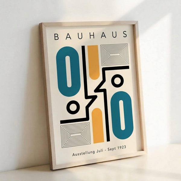 May include: Framed poster with abstract geometric design featuring teal oval shapes, orange vertical elements, black angular lines, circles, and rectangular patterns with concentric lines. Text reads "BAUHAUS" at top and "Ausstellung Juli - Sept 1923" at bottom. Light wood frame against white wall, casting soft shadows.