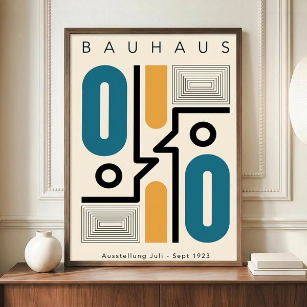 May include: Framed Bauhaus-style poster with geometric shapes in teal, orange, and black on cream background, displayed on wooden sideboard next to white ceramic vase and books in elegant room with white paneled walls