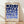 May include: Framed geometric art print with blue circular and semicircular shapes arranged in a grid pattern on cream background, displayed in light wood frame against white wall on wooden floor with natural lighting creating soft shadows