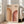 May include: Framed Bauhaus-inspired poster with geometric rainbow arcs in warm orange and burgundy tones against cream background, leaning against white wall next to beige upholstered sofa in bright, minimalist living room with large windows and natural light casting shadows on light wood floors.