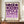 May include: Framed geometric poster with purple circles and semicircles in gradient shades from deep purple to lavender on cream background, text reading "BAUHAUS 1923" below the pattern. Brown wooden frame sits on walnut credenza next to small white ceramic vase and stacked books in bright room with white paneled walls.
