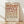 May include: Framed geometric poster with circles and semicircles in earth tones of terracotta, rust, tan, and beige arranged in a grid pattern. Text reads "BAUHAUS 1923" at bottom. Light wood frame sits on wooden floor against white wall with soft natural lighting casting shadows.