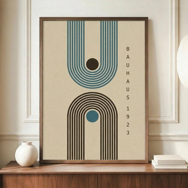 May include: Framed geometric poster with two arch designs in teal blue and brown on cream background, displayed on wooden credenza beside white ceramic vase and stacked books in elegant room with white paneled walls