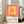 May include: Framed poster with concentric squares in gradient colors from pink outer border through orange and yellow to peach center, displayed against white wall next to beige upholstered sofa in bright living room with large windows and natural lighting on wooden floors.
