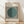 May include: Framed Bauhaus exhibition poster in light wood frame leaning against white wall on wooden floor. Design features black and white vertical stripes with large teal green circle overlay. Text reads "bauhaus ausstellung" at top and "WEIMAR JULI-SEPT 1923" at bottom on cream background. Minimalist geometric modernist style typical of 1920s Bauhaus movement. Natural lighting creates soft shadows on wall.