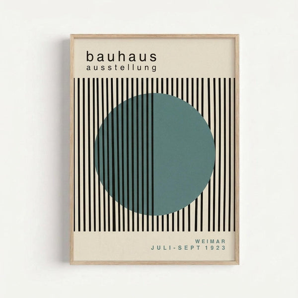 Framed Bauhaus exhibition poster with cream background featuring black and white vertical stripes and a large teal circle overlay. Text reads "bauhaus ausstellung" at top and "WEIMAR JULI-SEPT 1923" at bottom. Displayed in light wood frame against white wall in minimalist geometric modernist style.