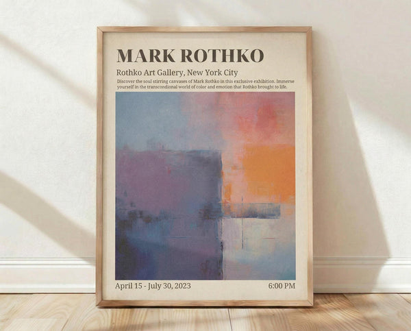 May include: Framed exhibition poster for Mark Rothko artwork displayed on light wooden floor against white wall with natural lighting creating shadows. The poster features abstract colorfield painting with blue, purple, orange and cream rectangular forms. Text shows gallery details and dates April 15 - July 30, 2023. Natural wood frame surrounds cream-colored poster on textured hardwood flooring.