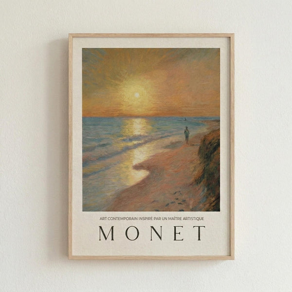 May include: Framed art print in light wood frame on white wall showing Impressionist-style painting of beach sunset scene with golden sun reflecting on water, solitary figure walking on sandy shore, warm orange and yellow sky. French text below reads "ART CONTEMPORAIN INSPIRÉ PAR UN MAÎTRE ARTISTIQUE" and "MONET" in large letters. White matting surrounds artwork.