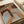 May include: Art print displayed on white upholstered furniture showing a woman with long dark hair and golden-brown skin tone against a burgundy background. The artwork features flowing blue and white curved lines throughout the composition, painted in an expressive style with warm earth tones. The print appears medium-sized relative to the cream-colored couch or chair beneath it.