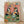 May include: Framed poster print leaning against white wall on light wooden floor. Artwork shows two cartoon penguins at party - one wearing colorful Hawaiian shirt and party hat holding martini glass, other in bow tie and sunglasses eating pizza slice. Pink background with multicolored "PENGUIN PARTY" text at top. Green table surface displays pizza, fish on plates, ice bowl, and champagne bottle. Natural wood frame, warm lighting with soft shadows.