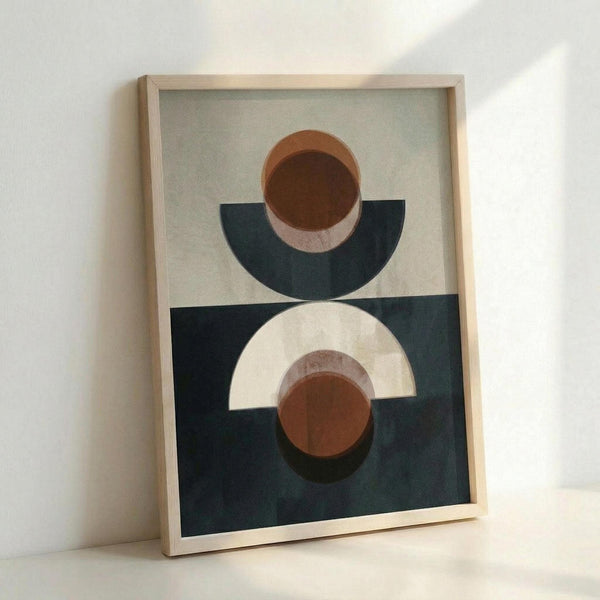 Framed geometric abstract art print featuring overlapping semicircles and circles in terracotta brown, cream, and navy blue colors. The artwork is displayed in a light wood frame against a white wall, showing the interplay of curved shapes against contrasting backgrounds in the upper and lower sections of the composition.